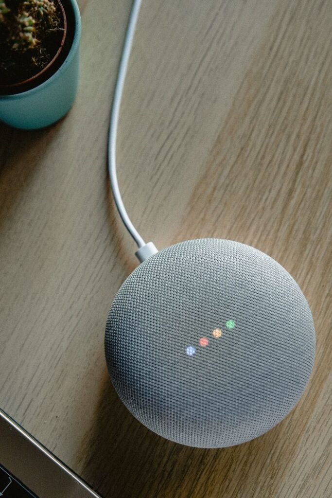 A top view of a smart speaker with a glowing indicator on a desk, emphasizing modern technology.